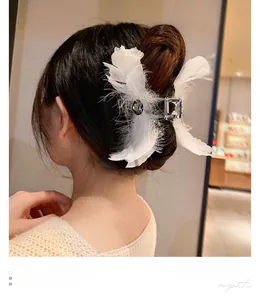 Détail d'une pince à cheveux en plumes d'autruche blanches avec pierre grise et base argent