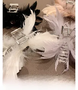 Détail de grandes pinces à cheveux en plumes d'autruche en noir blanc et tons pastels