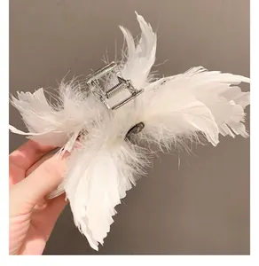 Vue détaillée de la grande pince à cheveux en plumes blanches avec cristal et ressort métal