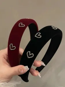 Close-up of vintage velvet headbands in burgundy and black with rhinestone heart details