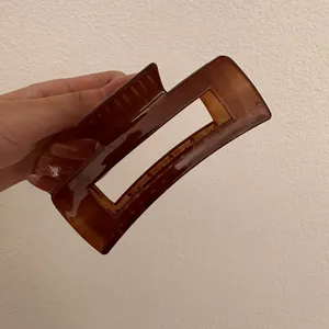 Detail van de grote amberkleurige rechthoekige haarklem voor dik haar styling