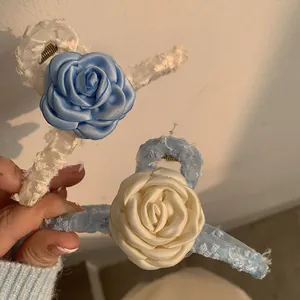 Détail de pinces à cheveux camélia avec roses en satin et dentelle à la main
