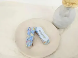 Detailed view of light blue knitted heart hair clips on a ceramic tray with dry flowers