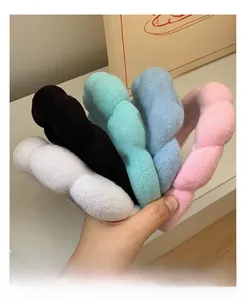Close-up of colorful twisted plush headbands in soft coral fleece for face washing