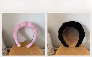 Detail of soft wave-shaped plush headbands in pink and black fleece for hair styling