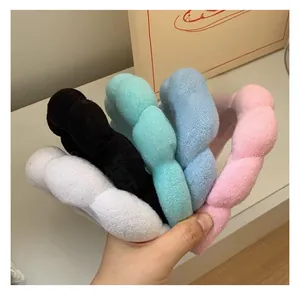 Close-up of fluffy plush twisted headbands in white, black, green, blue, and pink colors
