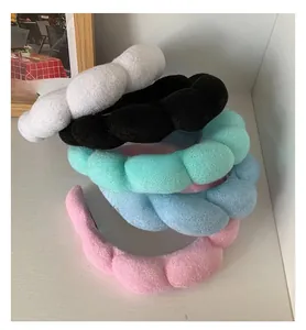 Close-up of colorful plush padded sponge headbands in white, pink, mint, and blue