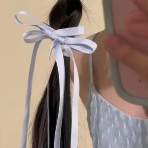 Elegant light blue satin ribbon bow hair clip with long streamers on dark straight hair