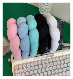 Detailed view of plush braided headbands in five pastel colors on a vintage typewriter