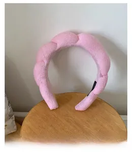 Detailed view of pink plush braided headband with a soft sponge design for extra volume