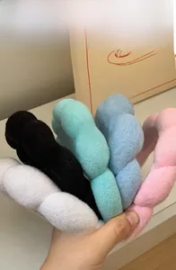 Detailed close-up of thick plush braided headbands in various colors for high skull top