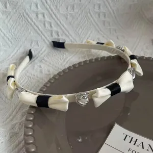 Elegante cerchietto con fiocchi neri e crema e cristalli lucenti a cuore