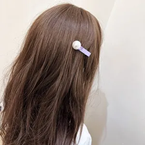 Elegant pearl hair clip with purple ribbon and square crystal on wavy brown hair