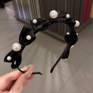 Elegant black satin bow headband decorated with white faux pearls for women