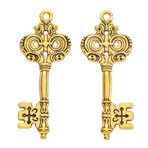 Close-up of vintage gold alloy key charms with cross relief for DIY jewelry crafts