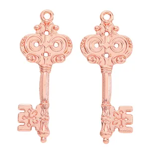 Detailed close-up of rose gold vintage key charms with ornate carvings and textured finish
