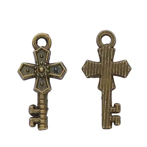 Vintage bronze alloy cross key pendant charms with embossed details on white background