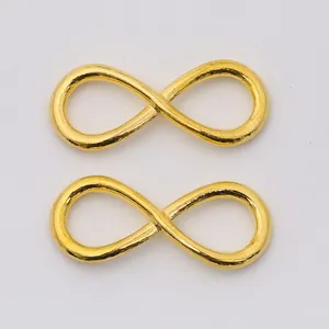 Pair of golden infinity symbol jewelry connectors for DIY accessories on white background