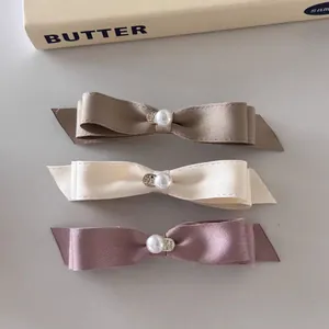 Ensemble de trois barrettes à nœuds en satin avec perles et pendentifs cœur ton pastel