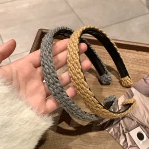 Detail of knitted headband showing grey and yellow braided texture and inner lining