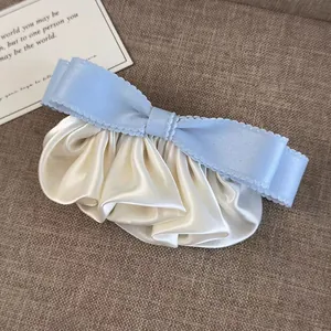 Barrette élégante à nœud bleu clair avec plis en satin sur fond de texture douce