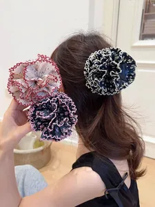 Detalle de pinzas para el cabello con forma de flores de gasa plisada en tres colores