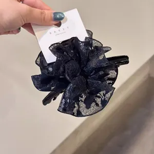 Vue détaillée de la grande pince à cheveux fleur en dentelle noire avec texture en maille