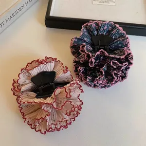 Detalle de dos pinzas para el cabello con flores plisadas en gasa rosa y azul marino