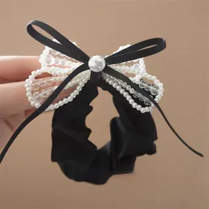 Elegant black bow hair scrunchie with pearls, crystals, and a sparkling silver button