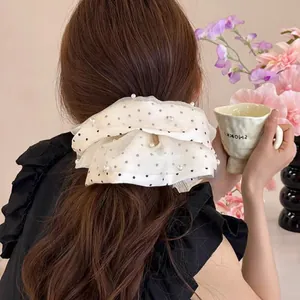 Chouchou en tulle double couche avec perles et pois sur les cheveux de femme