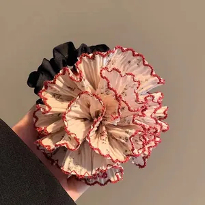 Vista de detalle de un coletero floral con pétalos crema y bordes rojos en zigzag