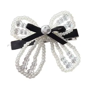 Elegant pearl and crystal bow hair clip with a black silk ribbon and silver button