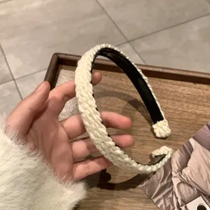 Detail of cream cable-knit headband with soft texture and non-slip inner lining