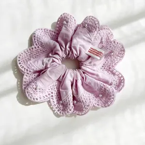 Detailopname van lavendel scrunchie met kanten randen en kleine witte pareltjes