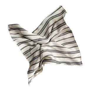 Détail d'un foulard carré en satin rayé au tissu brillant et aux lignes élégantes