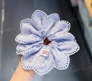 Detail van lavendelkleurige kanten scrunchie met witte parels en Seoul-oorsprongstag