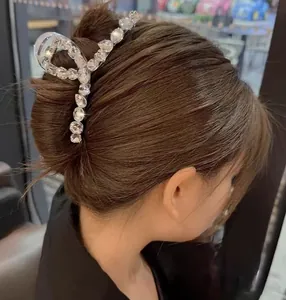 Détail d'une grande pince à cheveux ornée de cristaux brillants sur un chignon