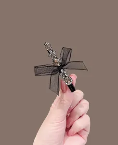 Detail of elegant black lace bow hair clip with sparkling rhinestones and crystal accents