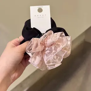 Détail d'un chouchou géant en dentelle florale avec contraste rose et noir élégant