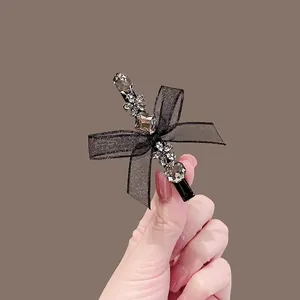 Elegant black lace bow hair clip with sparkling rhinestones and metal floral details