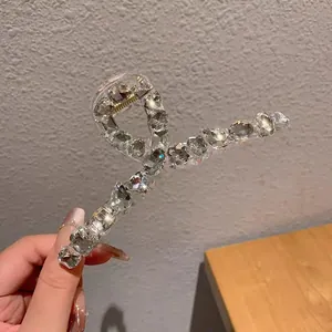 Gros plan de cristaux scintillants et strass sur une grande pince à cheveux en acrylique