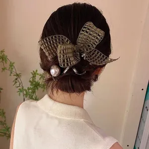 Elegant olive green lace bow hair clip with pearl detail styled on a low bun hairstyle