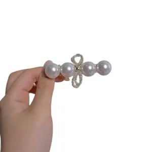 Elegant pearl hair clip with four large white pearls and a silver diamond bow accent