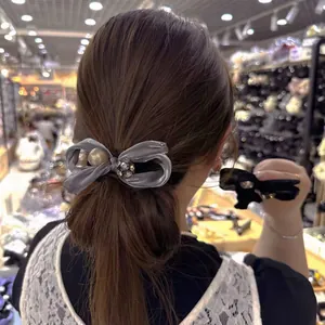 Elegant grey velvet bow hair clip with faux pearl and rhinestone ball on low ponytail