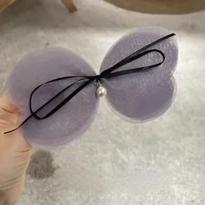 Detail of lavender mesh butterfly hair clip with black ribbon and white pearl drop