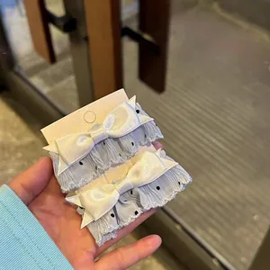 Sweet light blue polka dot fabric hair clips with white satin bows on display card