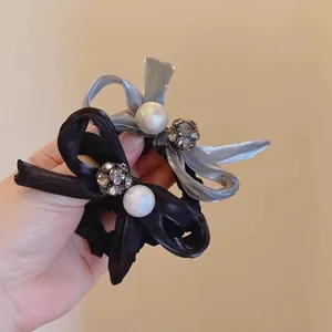 Elegant satin bow hair tie featuring a large white pearl and sparkling crystal ball