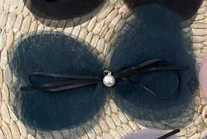 Detailed view of handmade mesh bow hair clip with pearl pendant and black ribbon accent