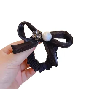 Elegant black silk bow hair tie with crystal pave ball and white pearl accessory
