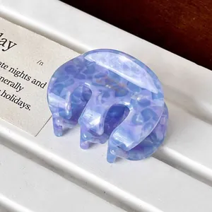 Detailed close-up of purple leopard acetate hair claw with golden Summer lettering
